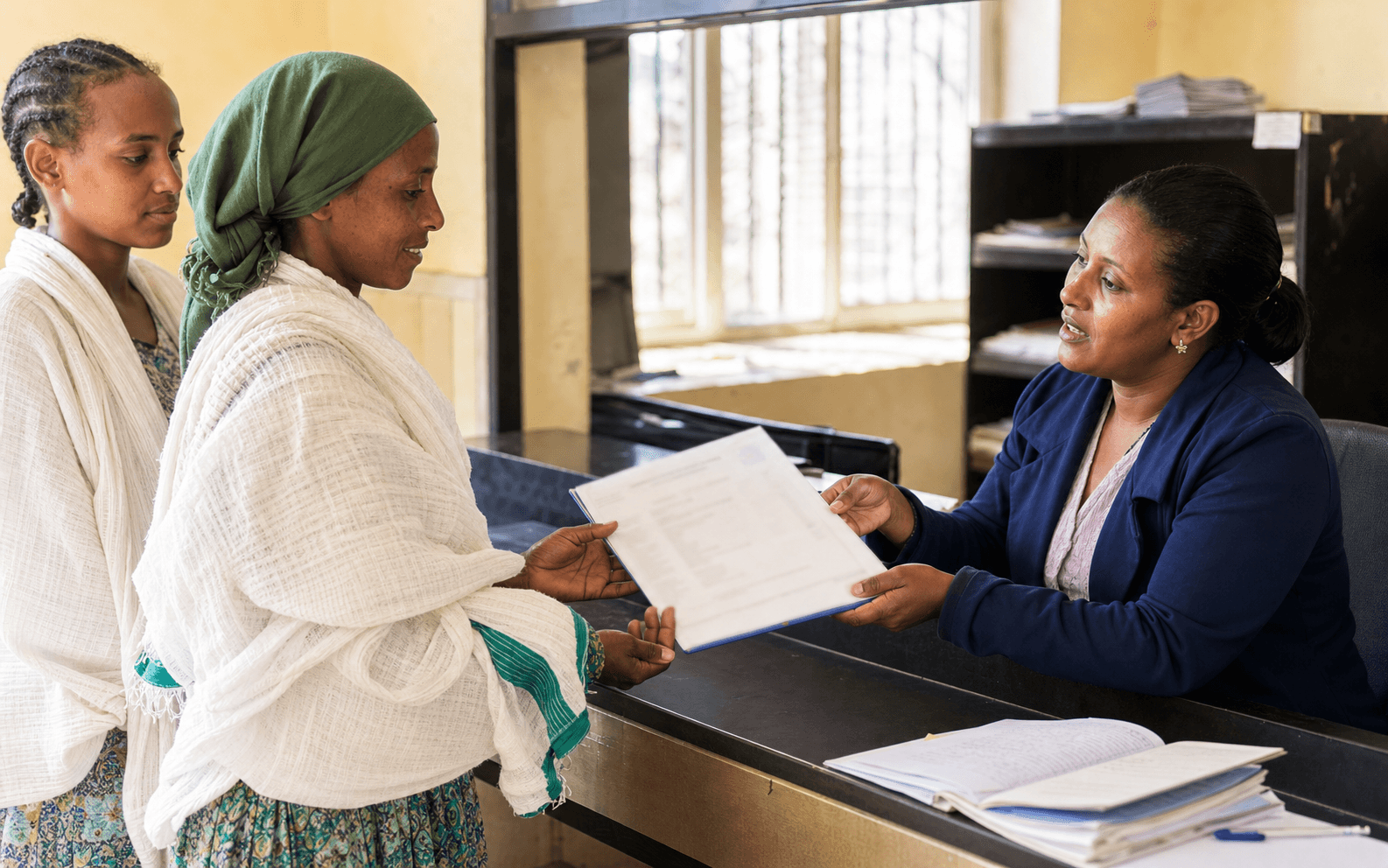 Ethiopian landholder receiving an approved landholding certificate at a service counter
